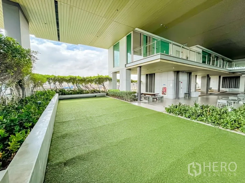 Condominium for sale - Covered garden terrace with artificial lawn, hedges and seating areas.