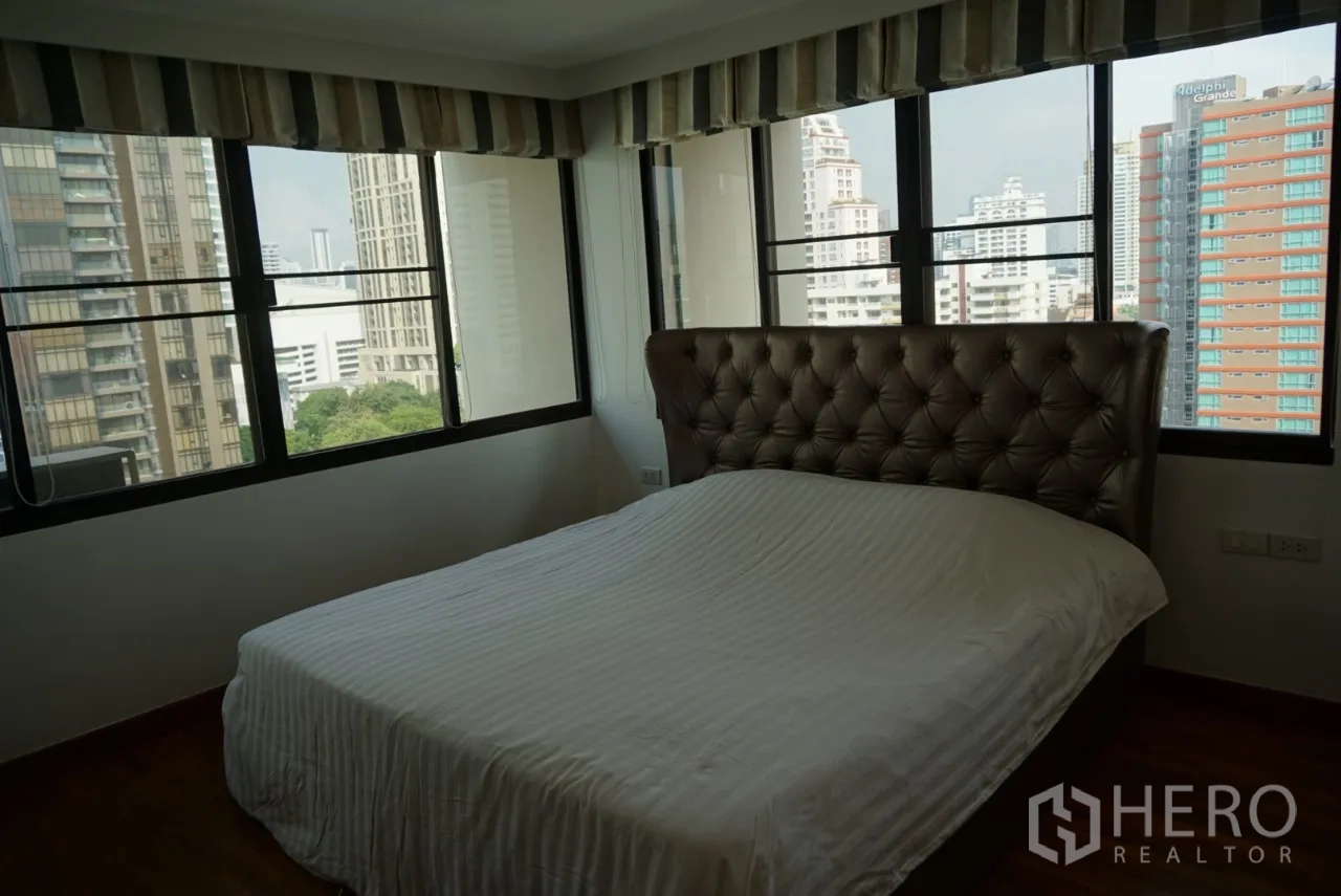 公寓 出租在Watthana, Bangkok - 主卧带软包床头与转角大窗，俯瞰曼谷天际线