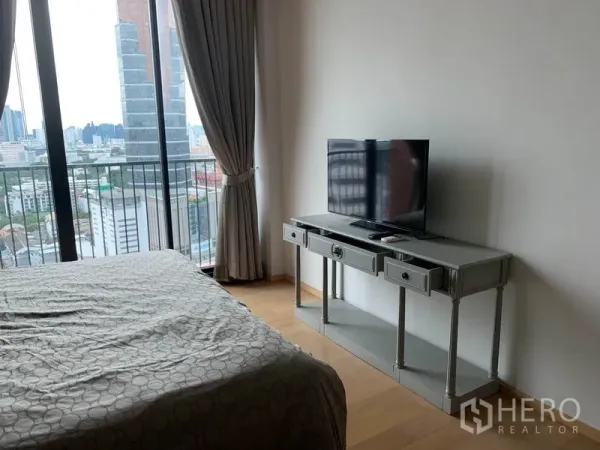 公寓 出租在Phaya Thai, Bangkok - 卧室配落地窗、电视柜与可观城市景的阳台。