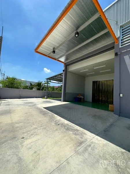 工厂 出租或出售在Lam Luk Ka, Pathum Thani - 工厂立面旁的带顶装卸区与车道，方便卡车进出。