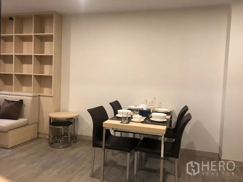 公寓 出租或出售在Yan Nawa, Bangkok - 餐区设四人餐桌，旁连客厅与开放式置物架。