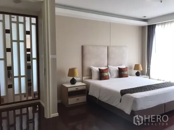 อพาร์ทเมนท์ ให้เช่าในKhlong Toei, Bangkok - ห้องนอนมาสเตอร์เตียงคิงไซส์ โต๊ะหัวเตียง แสงไฟอบอุ่น ข้างฉากกั้นตกแต่ง