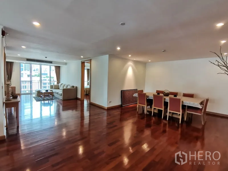 Condominium for rent in Khlong Toei, Bangkok - Wide view of the open-plan living and dining zone with abundant ceiling lights and balcony access.