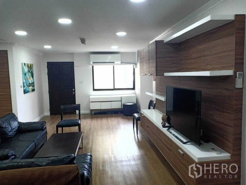 คอนโด ให้เช่าในWatthana, Bangkok - ห้องนั่งเล่นสว่าง พื้นไม้ ชุดชั้นวางทีวีบิวท์อิน และโซฟาหนัง ในคอนโดย่านพร้อมพงษ์