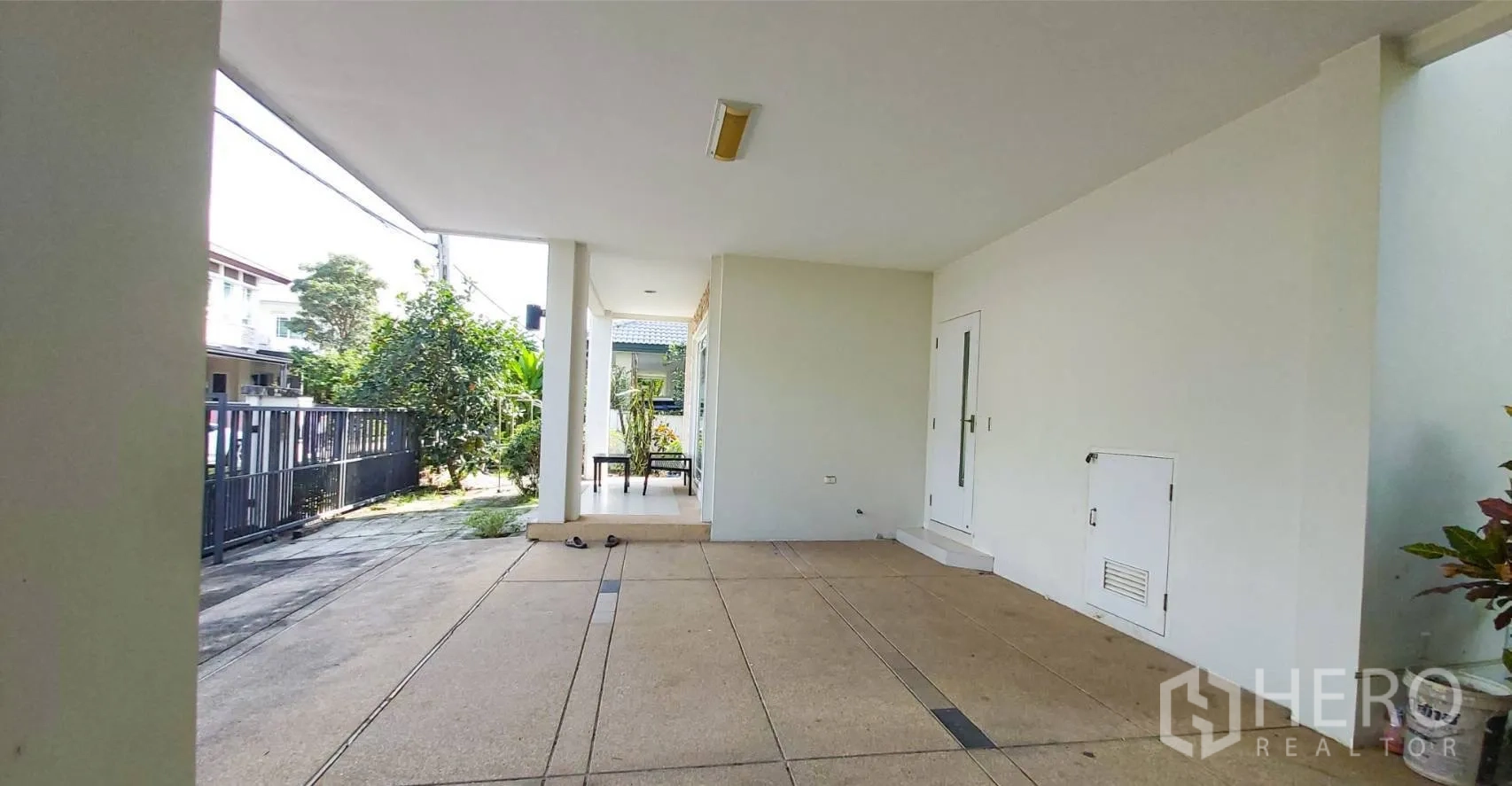 Detached House for sale in Bang Kapi, Bangkok - Covered carport and front porch next to a small garden walkway.