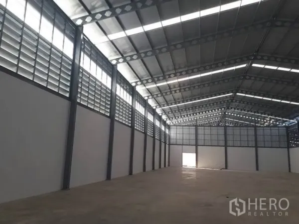 Warehouse for rent in Bang Phli, Samut Prakan - Interior wall lined with louvered ventilation panels beneath a tall gabled roof.