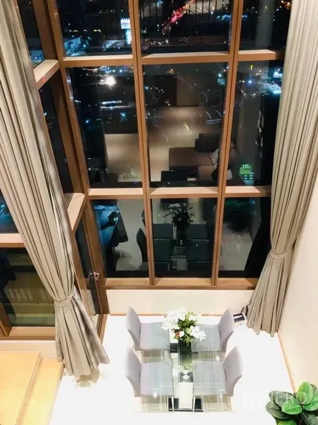 公寓 出租在Khlong Toei, Bangkok - 空堤区曼谷公寓的挑高客餐厅，落地窗俯瞰夜景。
