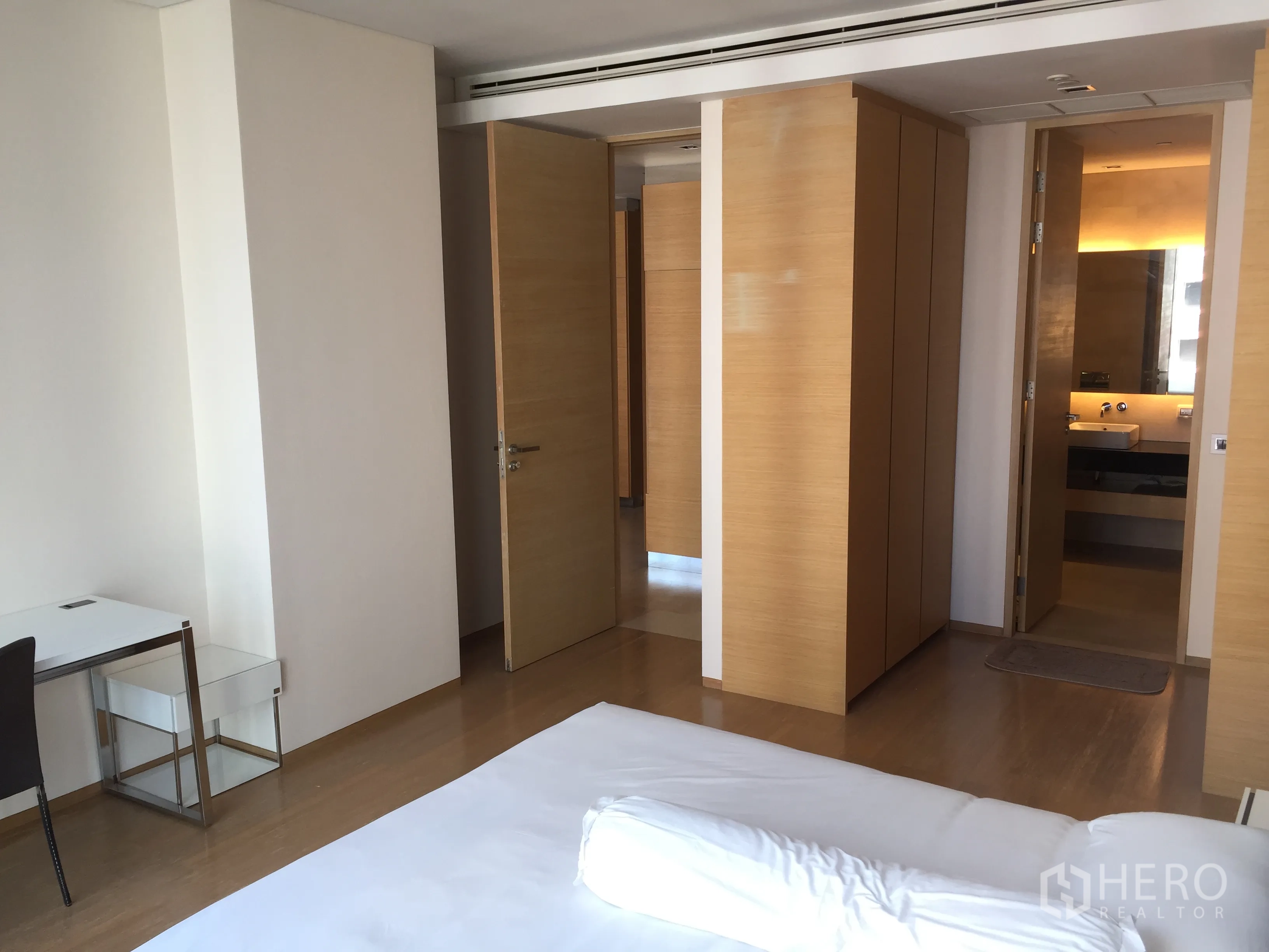 Condominium for rent or sale in Bang Rak, Bangkok - Bright bedroom with built-in wardrobes, desk and ensuite bathroom access.