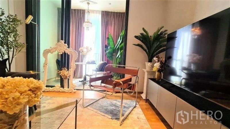 Condominium for rent in Khlong Toei, Bangkok - Living area with TV console and sliding doors opening to a glass-enclosed sunroom.