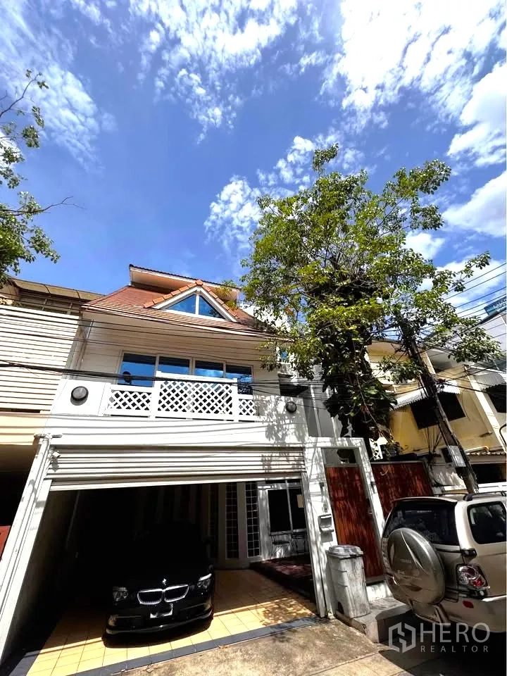 Townhouse for rent in Huai Khwang, Bangkok - Townhouse exterior with covered carport and upper balcony.
