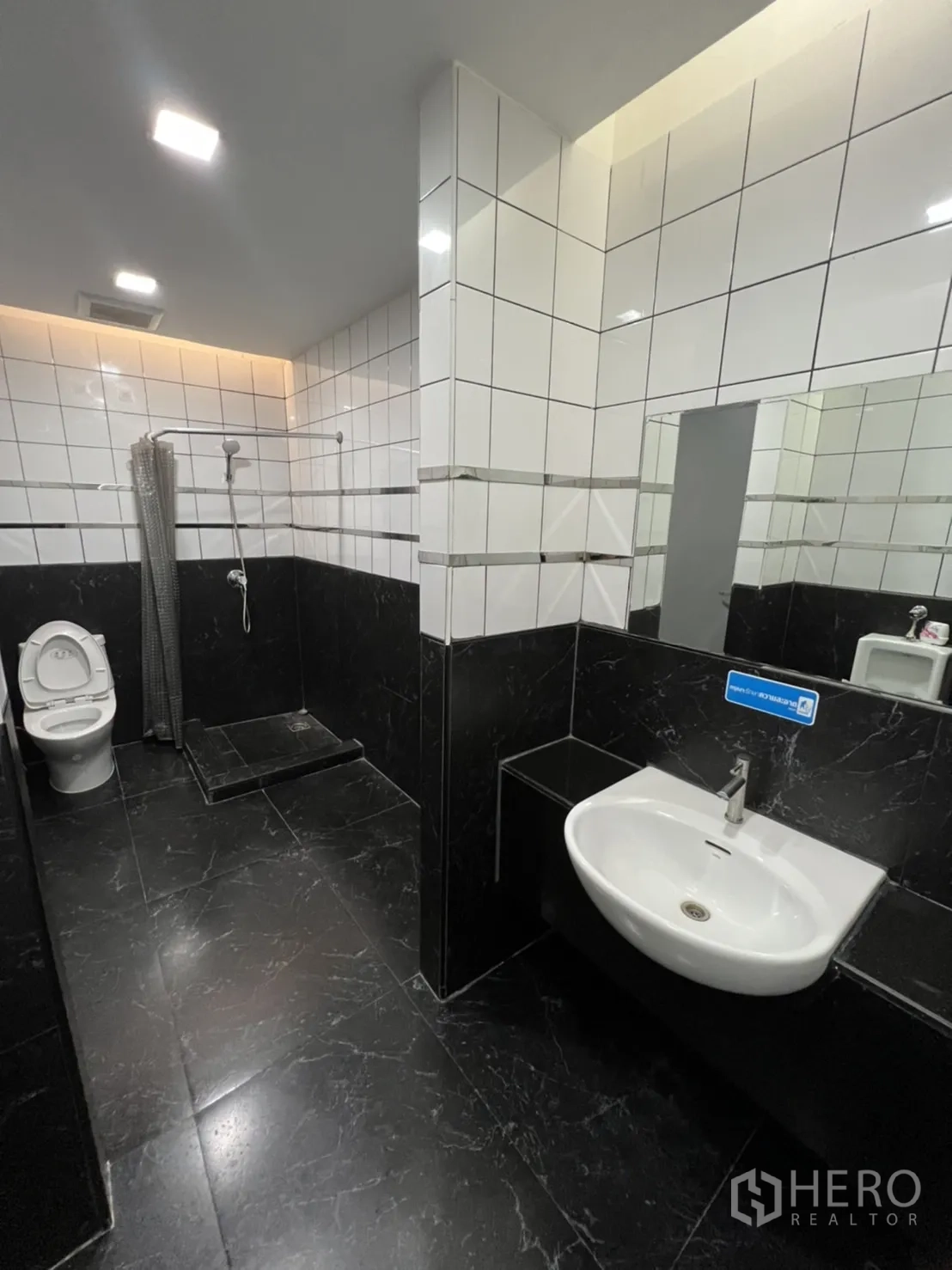 Retail Space for rent in Sathon, Bangkok - Tiled bathroom with shower area, toilet and wall-mounted basin.
