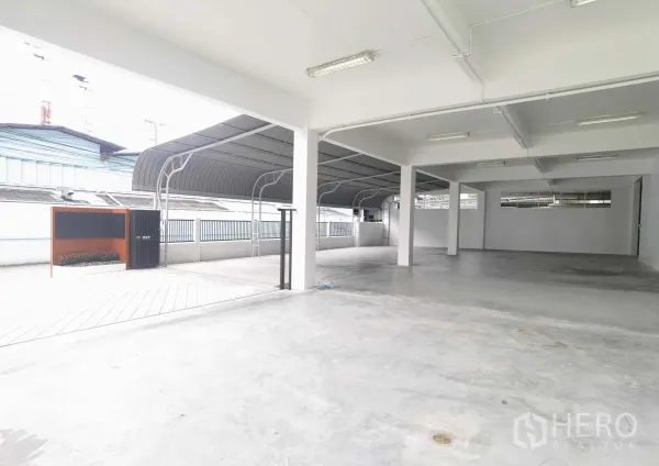 Warehouse for rent in Samut Prakan - Covered ground‑level loading and parking area with concrete floor and metal canopy at the Bang Na warehouse.