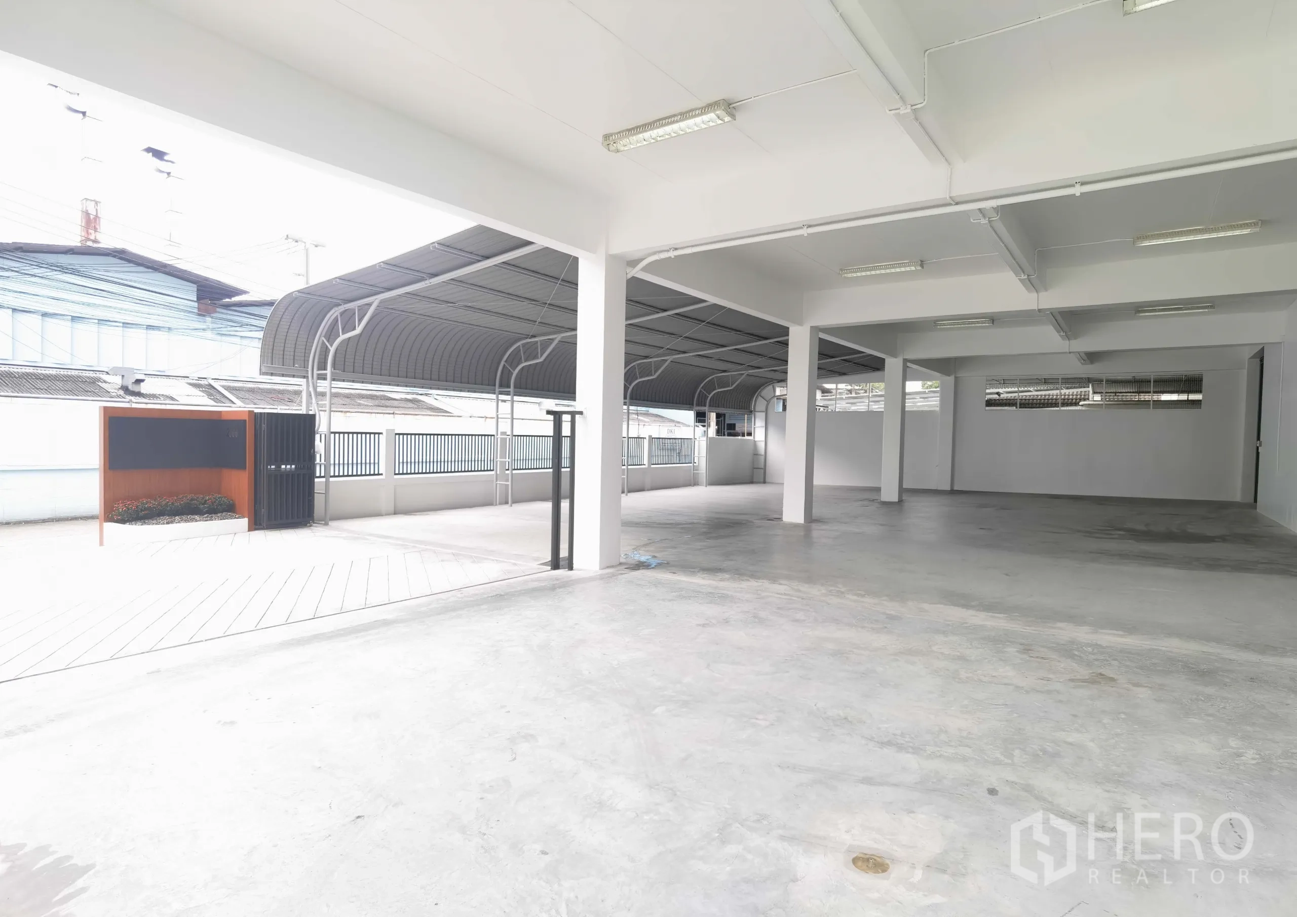 Warehouse for rent in Samut Prakan - Covered ground‑level loading and parking area with concrete floor and metal canopy at the Bang Na warehouse.