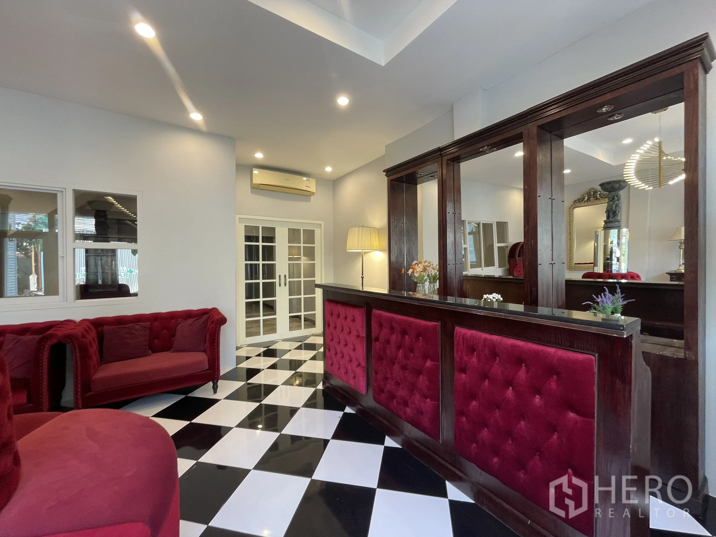 店屋 for rent in Bang Kapi, Bangkok - 加长接待柜台，镜面柜体、红色天鹅绒装饰与射灯。