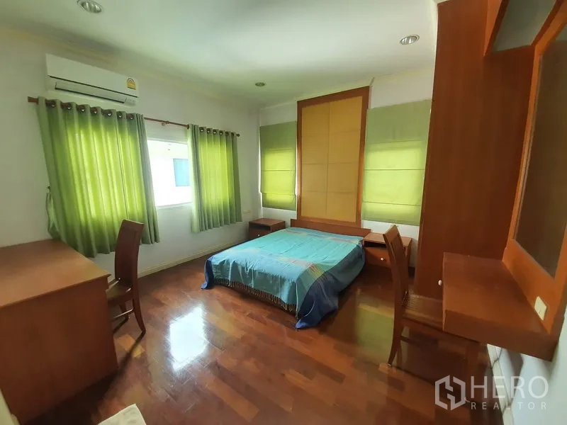 独立式住宅 出租在Lat Krabang, Bangkok - 卧室配空调与双人床，木地板，内置书桌与衣柜。