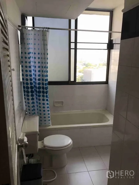 Condominium for rent or sale in Watthana, Bangkok - Bathroom with bathtub, big window and clean white tiles providing natural light.