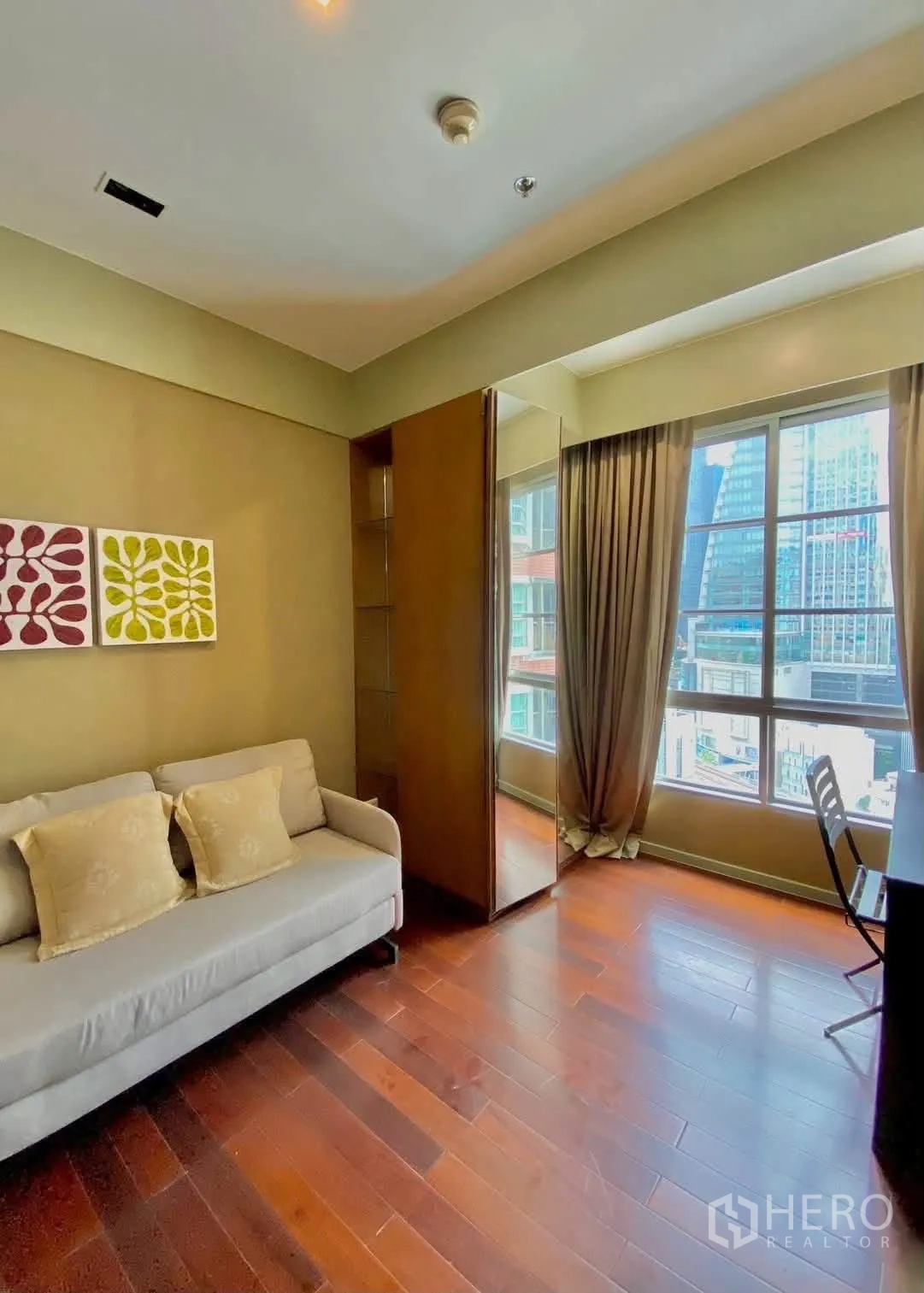 คอนโด for rent in Khlong Toei, Bangkok - ห้องนั่งเล่นขนาดกะทัดรัดพร้อมโซฟา โต๊ะทำงาน และหน้าต่างบานใหญ่เห็นวิวเมือง