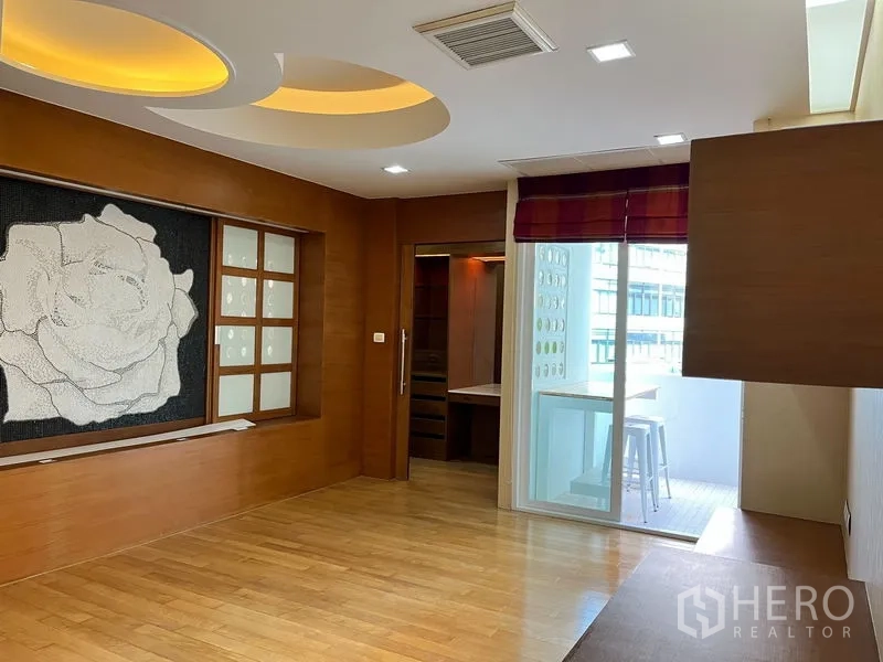 公寓 出租在Khlong Toei, Bangkok - 卧室/起居区，木质墙面、氛围灯槽与推拉门连阳台。