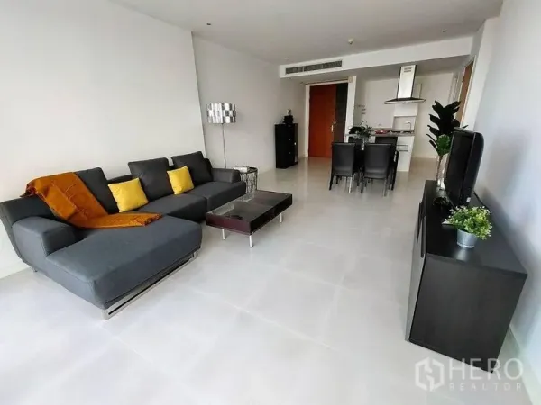 Condominium for rent in Watthana, Bangkok - Spacious living room with sectional sofa, TV console and large sliding doors to city views.