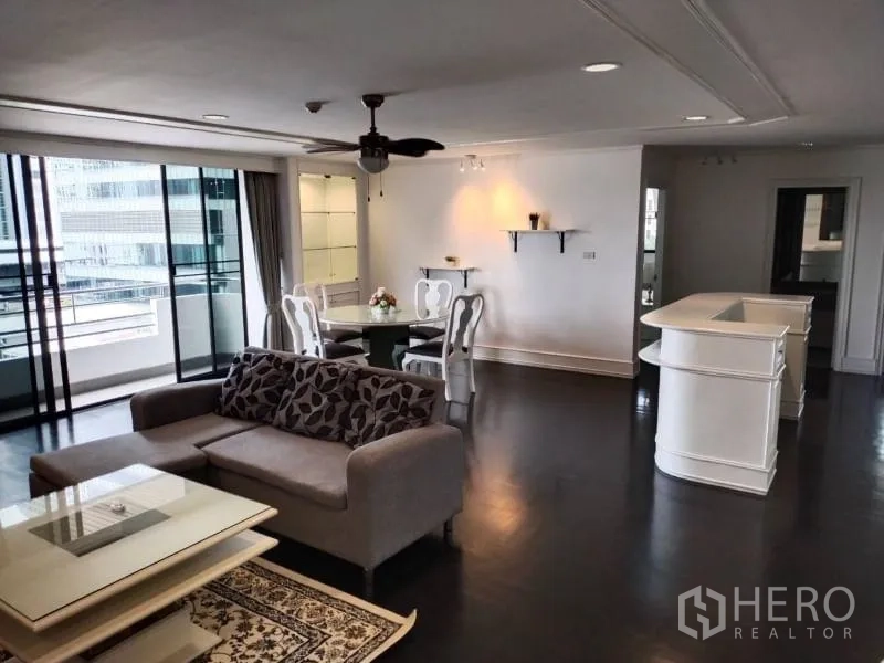Condominium for rent in Sathon, Bangkok - Spacious open-plan living and dining area with a ceiling fan and sliding doors to a balcony.