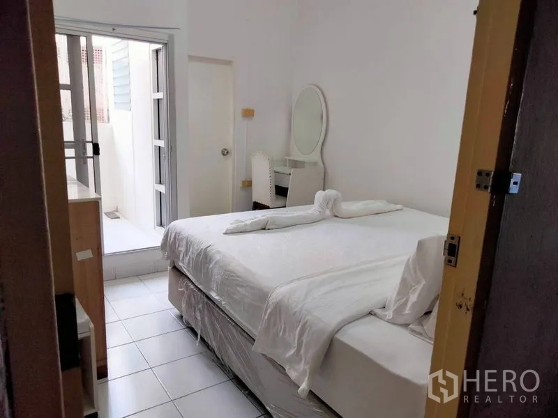 Shophouse for rent - Bedroom opening to a small balcony with dressing table and abundant natural light.