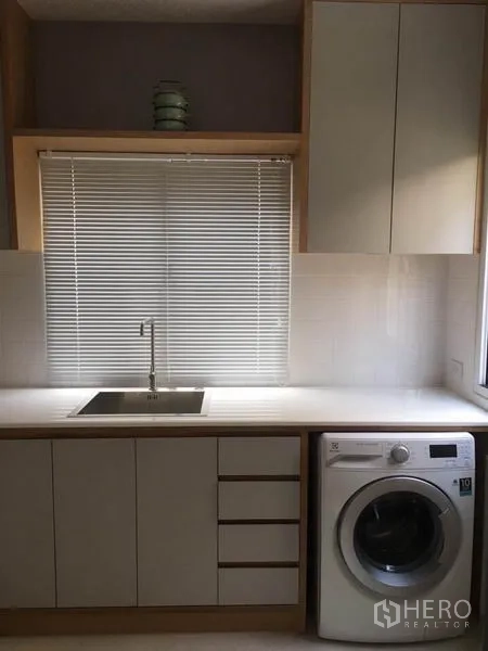 Detached House for rent in Suan Luang, Bangkok - Utility zone with sink, cabinetry and front-loading washing machine.
