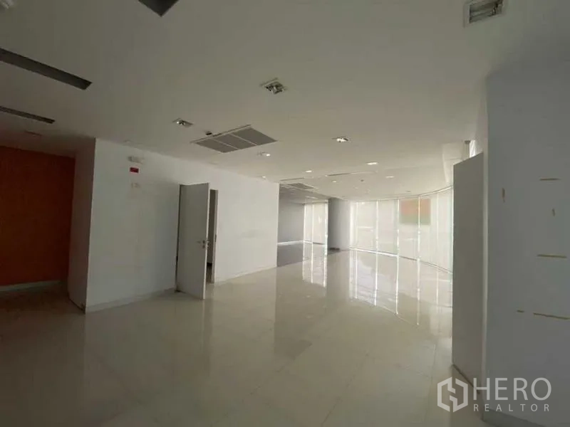 Retail Space for rent - Spacious showroom zone with glossy tiles, recessed lighting and curved glass frontage.