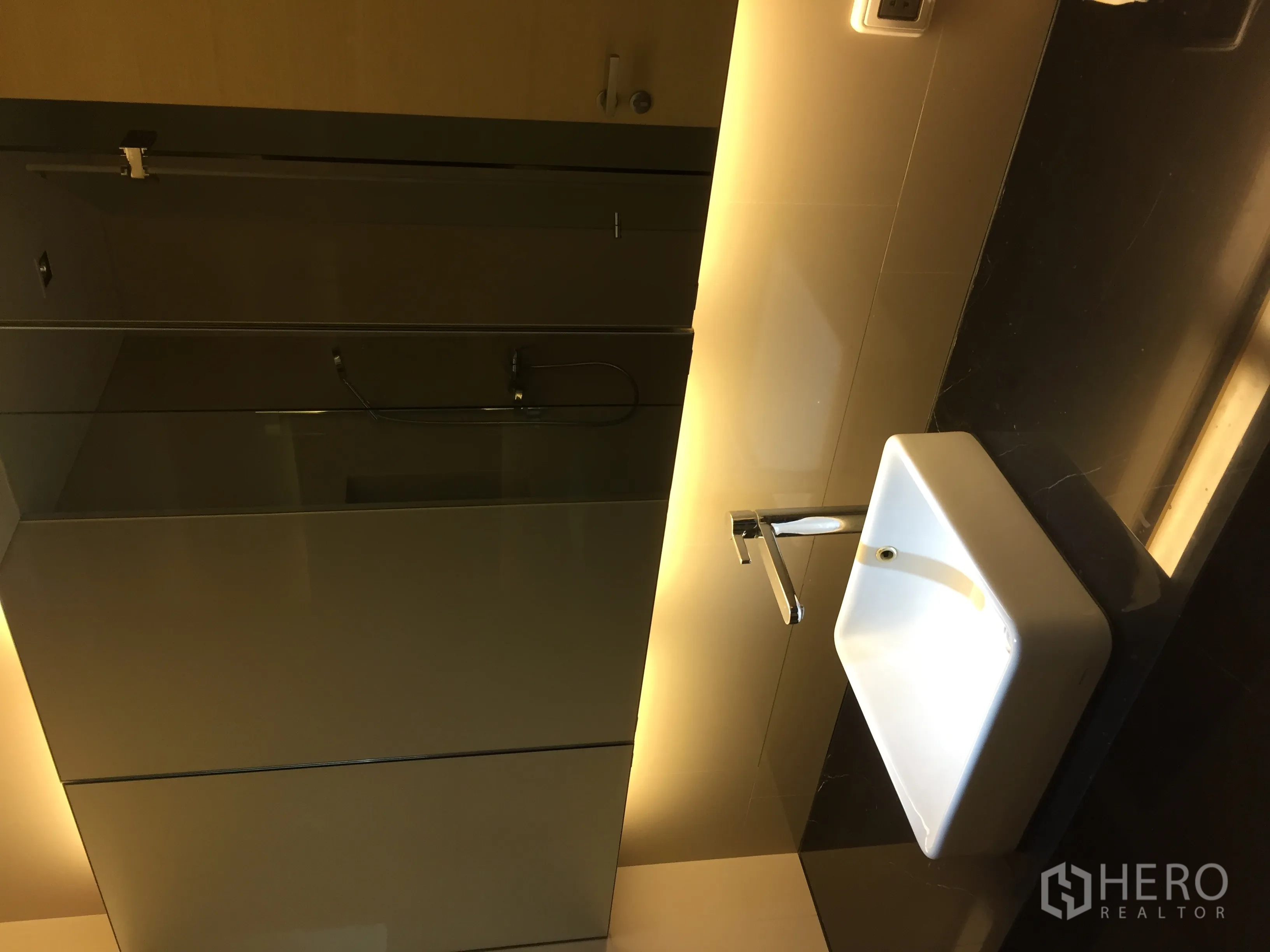 Condominium for rent or sale in Bang Rak, Bangkok - Contemporary bathroom with backlit mirror and square countertop sink.