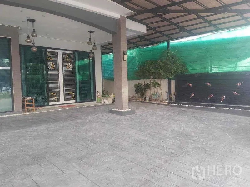 Detached House for rent or sale in Prawet, Bangkok - Spacious covered patio and driveway with pendant lights and decorative water feature wall.
