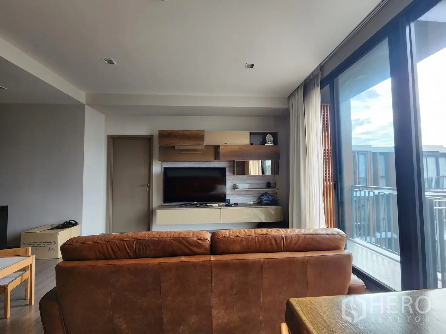 公寓 for rent in Watthana, Bangkok - 餐区望向客厅电视柜与阳台，室内自然采光充足。