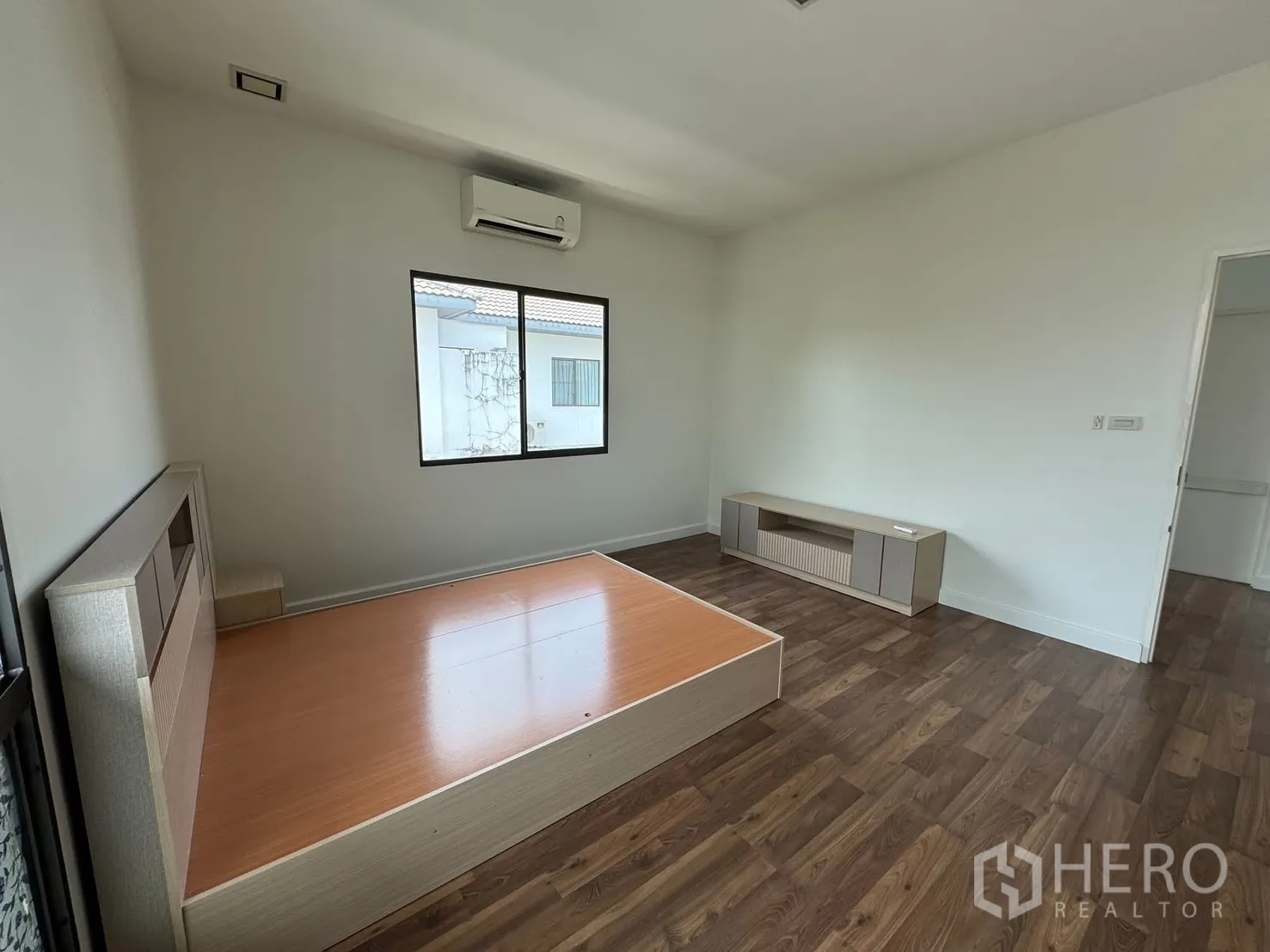 Detached House for rent in Prawet, Bangkok - Bedroom view toward the doorway with platform bed and low console.