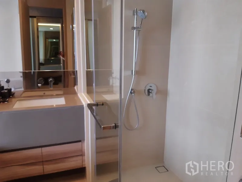 公寓 出租或出售在Watthana, Bangkok - 现代浴室，玻璃淋浴间与宽大盥洗台。