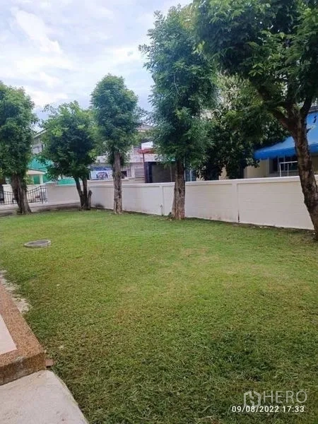 บ้าน ขายในPrawet, Bangkok - สนามหญ้าสีเขียวมีต้นไม้เรียงตามแนวรั้ว