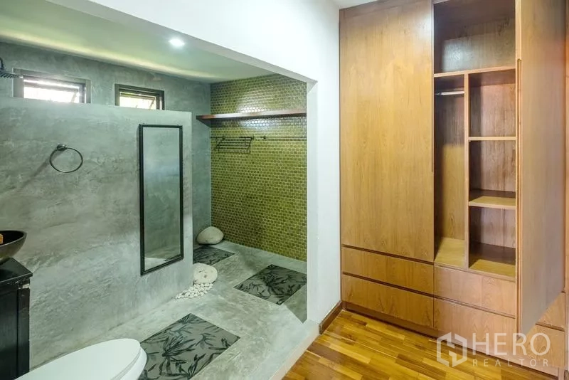Detached House for sale in Bang Lamung, Chon Buri - Ensuite bathroom and wardrobe area with concrete finish and a walk-in shower.