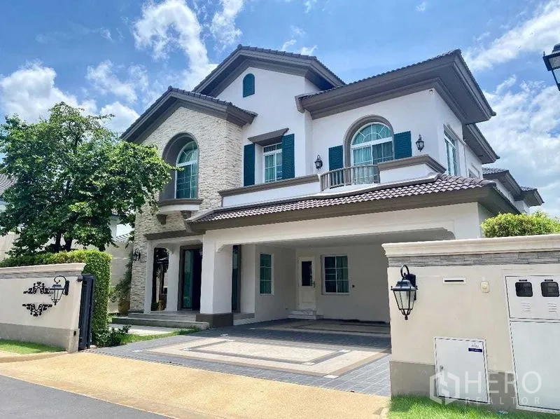 บ้าน ให้เช่าในBang Khen, Bangkok - ภาพด้านหน้าอีกมุมของตัวบ้าน พร้อมทางรถเข้าและสวนจัดแต่ง