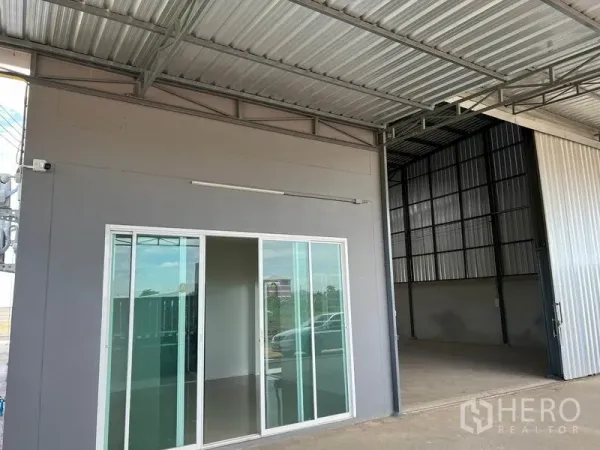 Warehouse for rent in Lam Luk Ka, Pathum Thani - Sliding glass office entrance opening to a roofed loading area with steel structure.