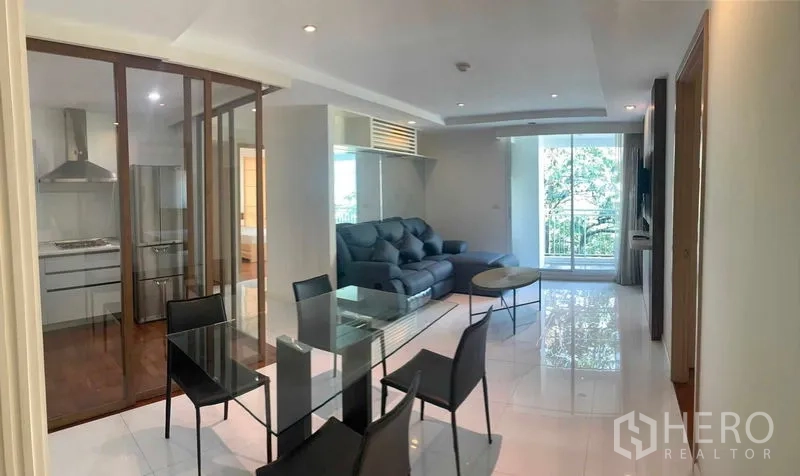 Condominium for rent or sale in Khlong Toei, Bangkok - Long view from dining to living room opening to a tree-lined balcony.