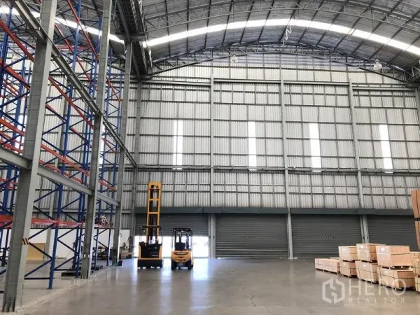 货栈 出租在Bang Pakong, Chachoengsao - 装卸区配多扇卷帘门，挑高空间与叉车，地面为光滑混凝土