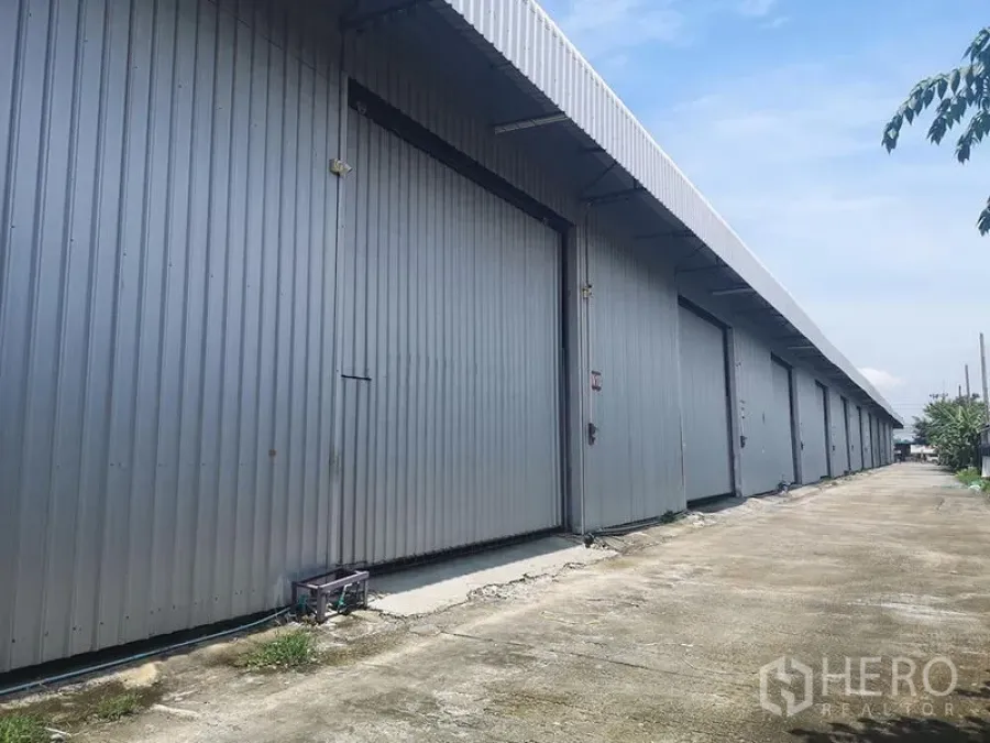 货栈 出租在Lam Luk Ka, Pathum Thani - 金属板外墙的仓库外立面，多个大型滑动门与车道出入口。