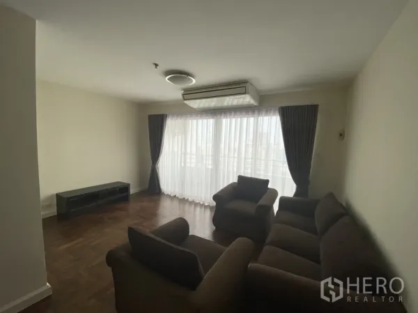公寓 出租在Watthana, Bangkok - 更宽视角的起居区，沙发组、壁挂空调和电视柜。