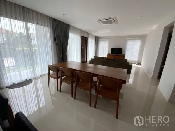 Townhouse for rent in Prawet, Bangkok - Bright open-plan living and dining room with large windows, sheer curtains and glossy floors.