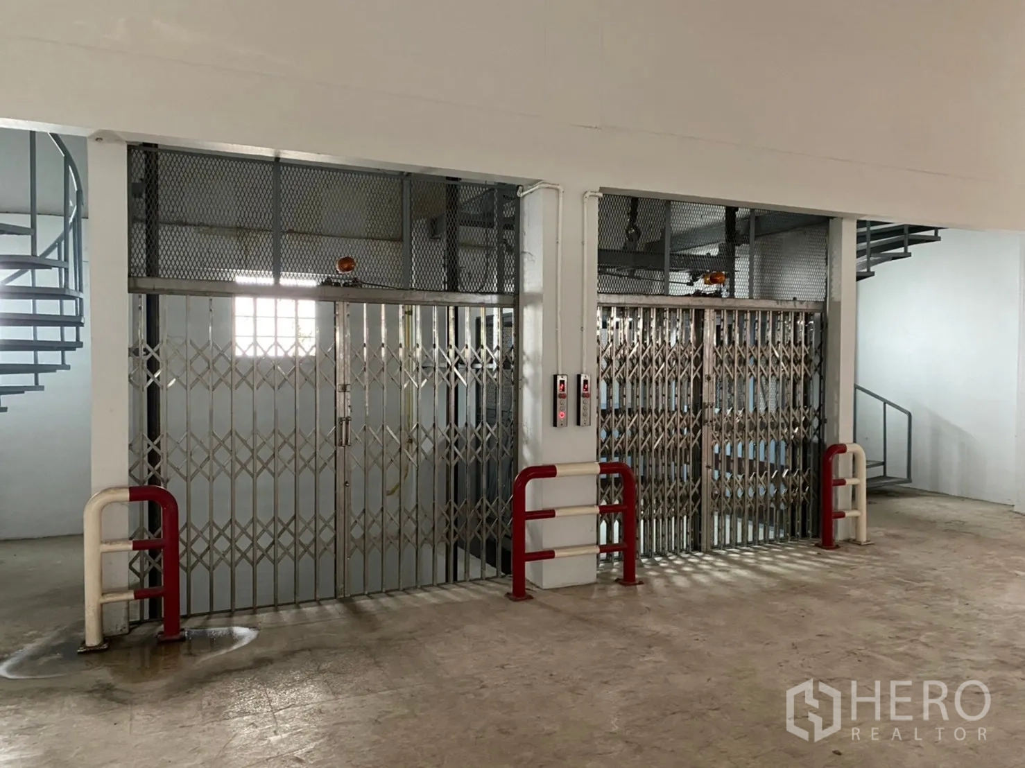Warehouse for rent in Lat Krabang, Bangkok - Dual cargo lifts with folding metal gates and protective bollards.