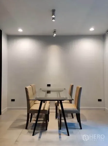 Townhouse for rent in Suan Luang, Bangkok - Minimal dining area with a glass-top table and four upholstered chairs