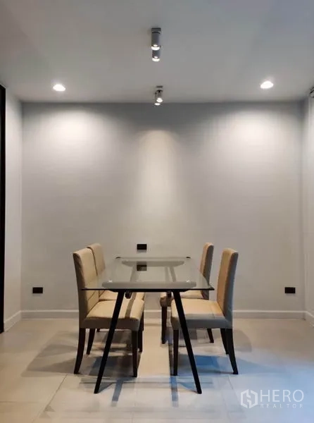 Townhouse for rent in Suan Luang, Bangkok - Minimal dining area with a glass-top table and four upholstered chairs