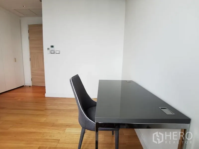 Condominium for rent in Pathum Wan, Bangkok - Quiet corner with modern desk and chair on wooden flooring, ideal for a home office.