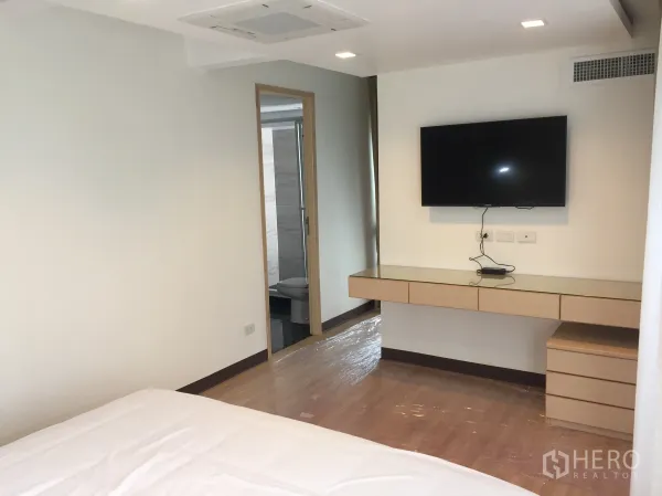 公寓 出租在Pathum Wan, Bangkok - 主卧配壁挂电视、悬空书桌，并有通往套内浴室的门