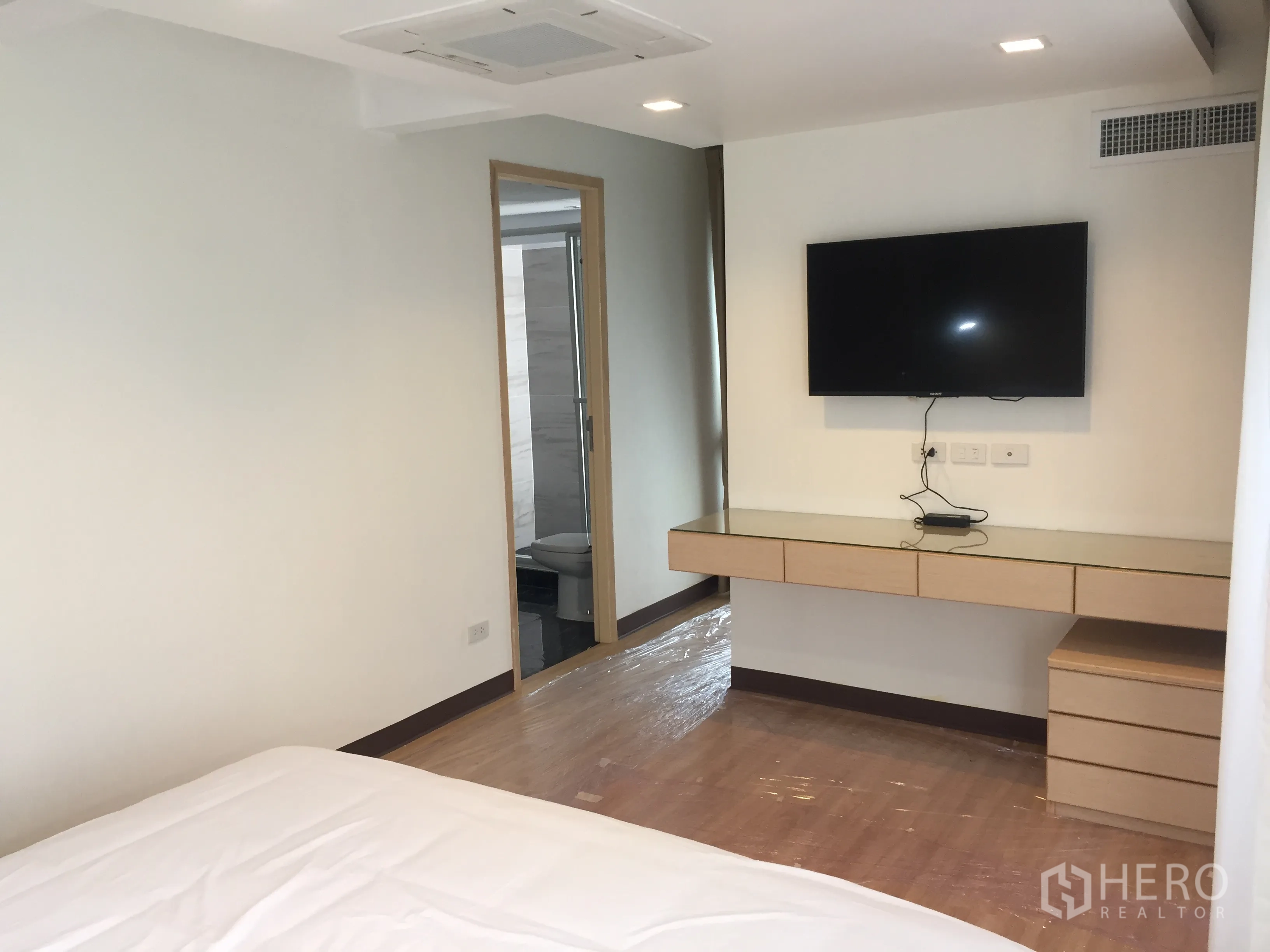 公寓 出租在Pathum Wan, Bangkok - 主卧配壁挂电视、悬空书桌，并有通往套内浴室的门