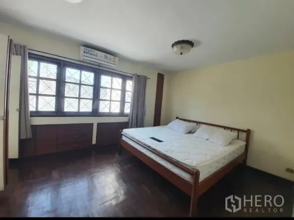 联排别墅 出租在Watthana, Bangkok - 宽敞主卧，拼花木地板与内置收纳。