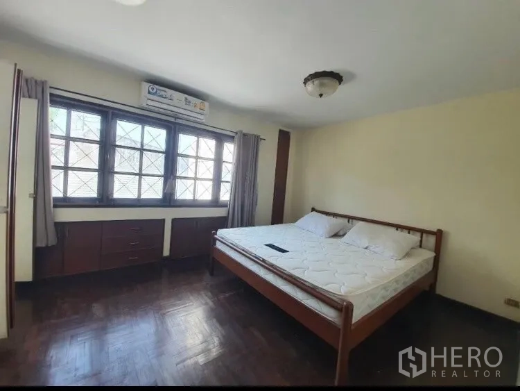 联排别墅 出租在Watthana, Bangkok - 宽敞主卧，拼花木地板与内置收纳。