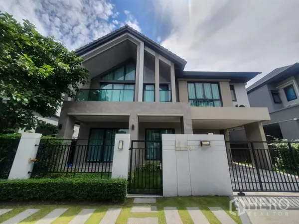 Detached House for rent in Khlong Luang, Pathum Thani - Modern two-storey detached house with gated front yard, balcony and driveway.